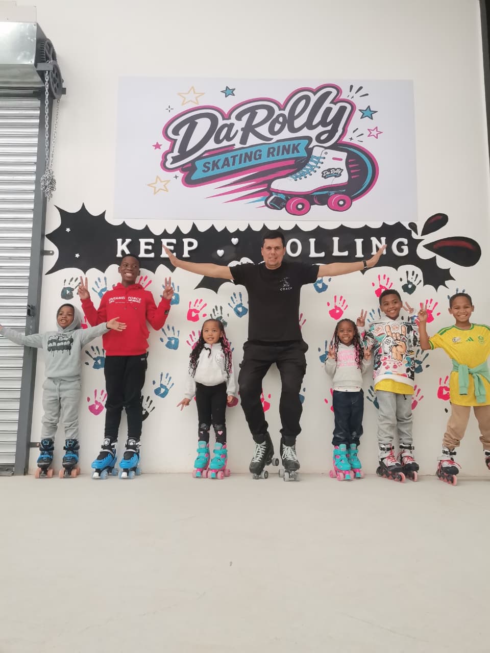 Da Rolly coach and kids celebrating at the mural